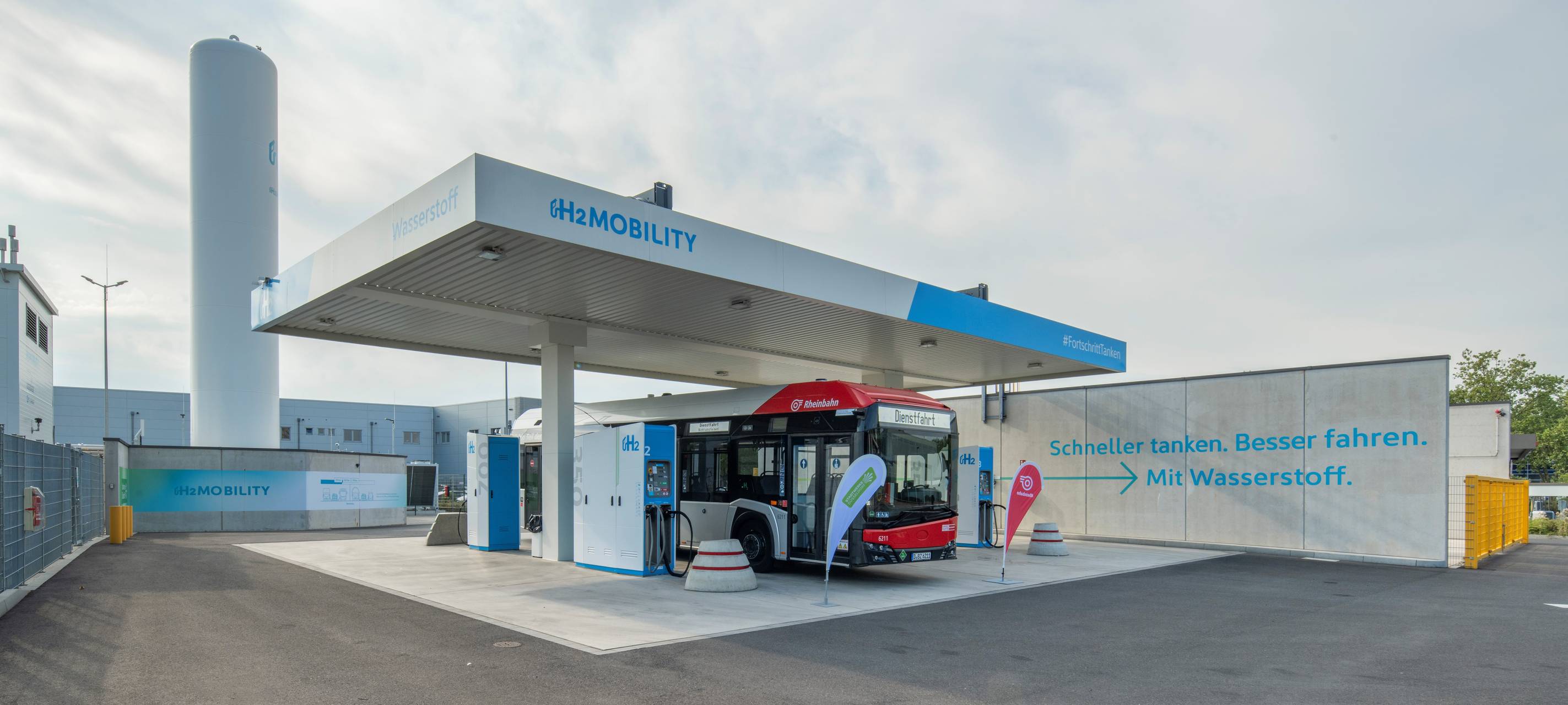 Ein Rheinbahn-Bus steht an einer neuen, großen Wasserstoff-Tankstelle.