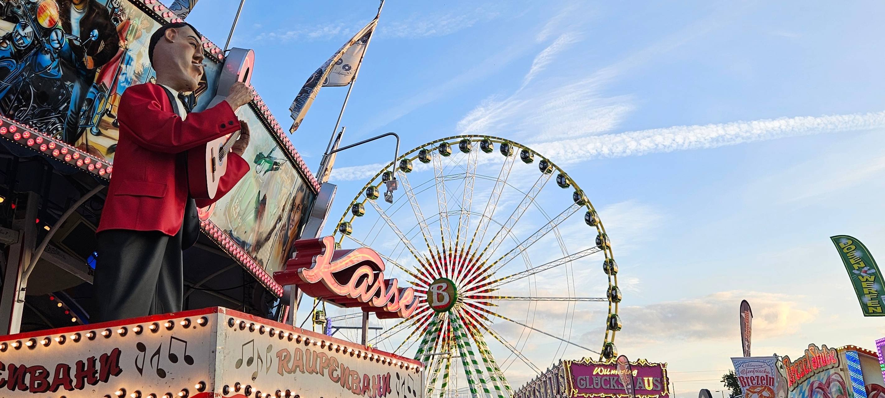 Auf der Rheinkirmes ansicht der Raupenbahnkasse und das Riesenrad im Hintergrund.