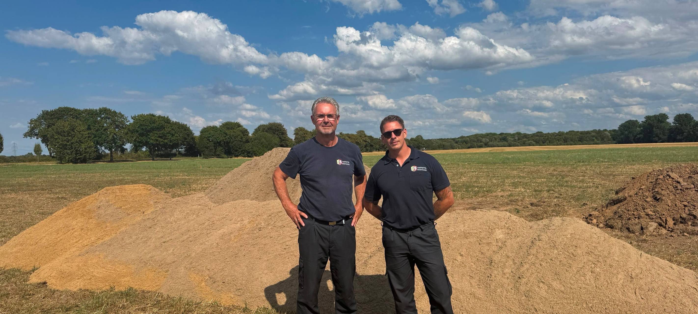 Die bei Sondierungsarbeiten in Düsseldorf-Kalkum gefundene Panzergranate aus dem Zweiten Weltkrieg konnte am Mittwoch, 5. August 2026, durch Sprengmeister Julian Granzow (r.) und Kampfmittelbeseitiger Michael Hoff vom Kampfmittelbeseitigungsdienst der Bezirksregierung erfolgreich kontrolliert gesprengt werden.
