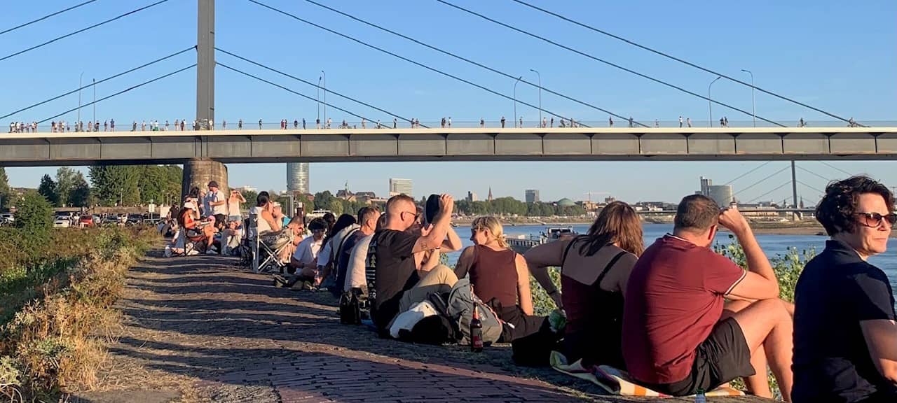 Menschen am Rheinufer zur Sonnenfinsternis 2026