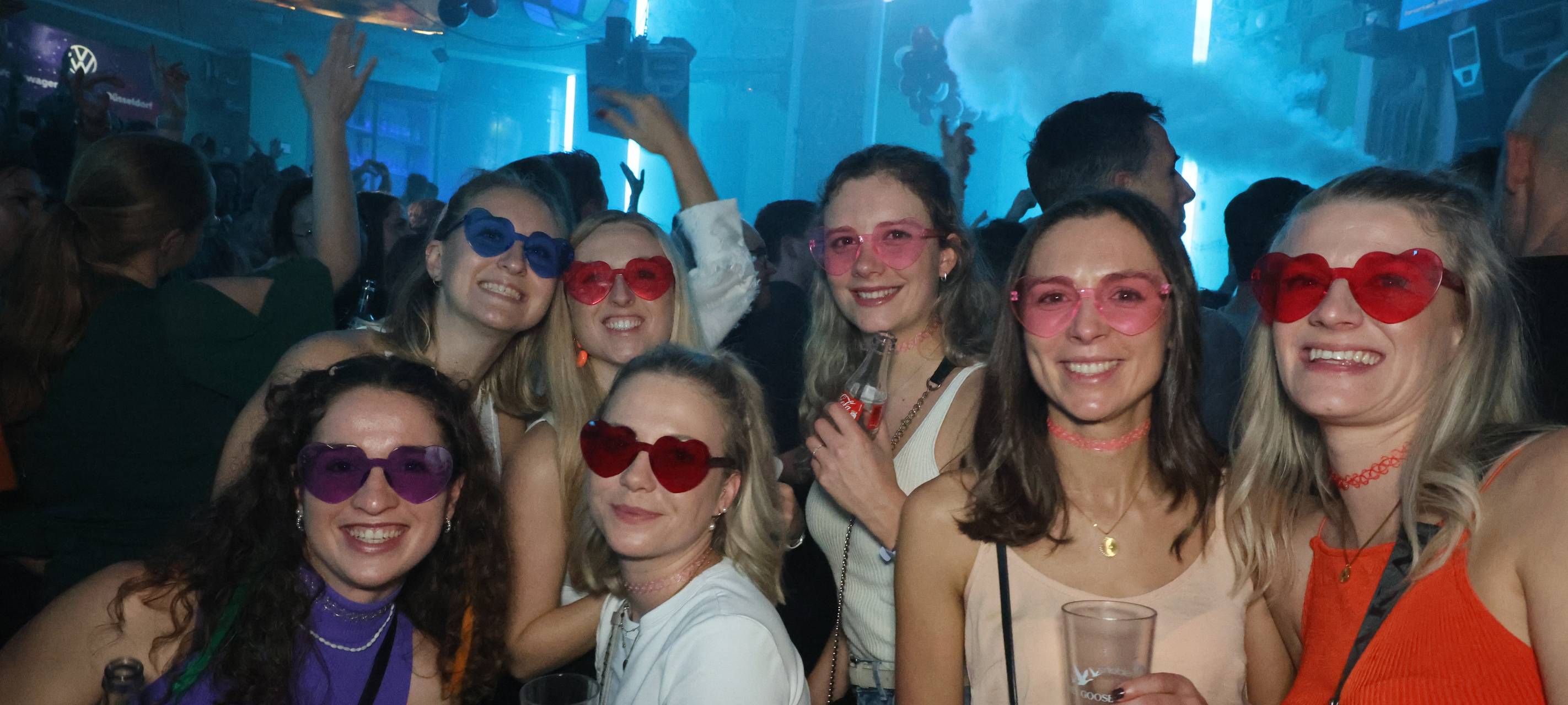 Feiernde Partygäste mit bunten Herz-Sonnenbrillen in der voll besetzten Nachtresidenz bei einer Veranstaltung von Antenne Düsseldorf.