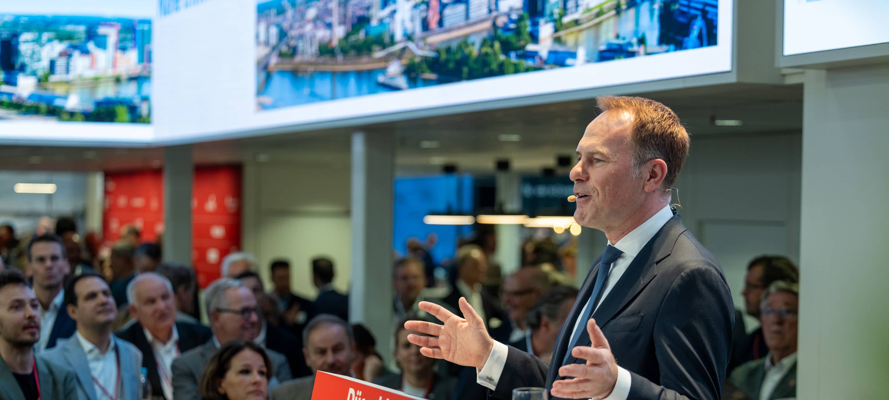 OB Keller steht auf der Bühne bei der Expo Real und hört eine Rede vor Gästen.