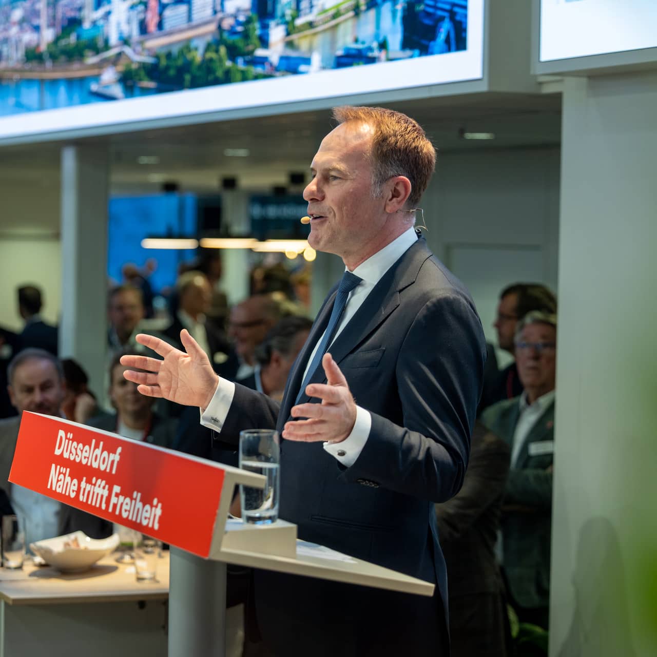 OB Keller steht auf der Bühne bei der Expo Real und hört eine Rede vor Gästen.