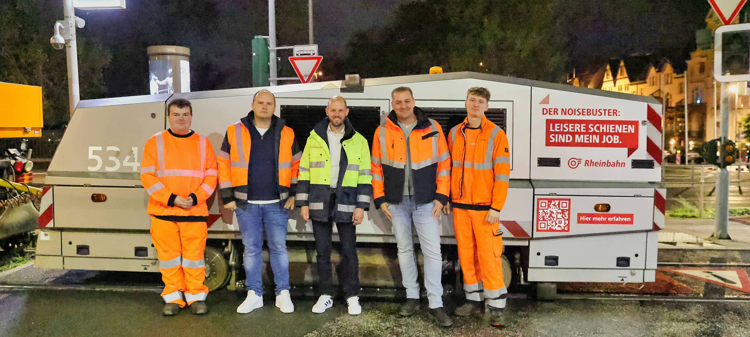 Christian Finke (Mitte), Vorstand Betrieb und Infrastruktur der Rheinbahn, mit Lukas Thomalla (stellvertretender Abteilungsleiter Fahrwege/2. von links)), Projekteiter Andreas Busch (4. von links) und den beiden Fahrern David Zieren (links) und Denis Alekseev (rechts) vor dem HSG-city.