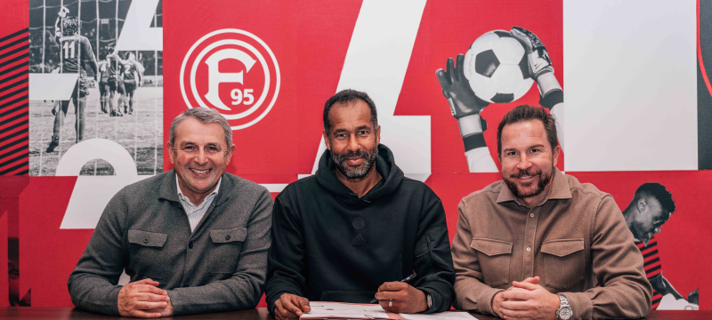 Klaus Allofs, Daniel Thioune und Christian Weber sitzen an einem Tisch und verkünden die Vertragsverlängerung von Trainer Daniel Thioune