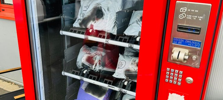 Ein roter Secret-Pack-Automat. Er ist mit Paketen gefüllt.
