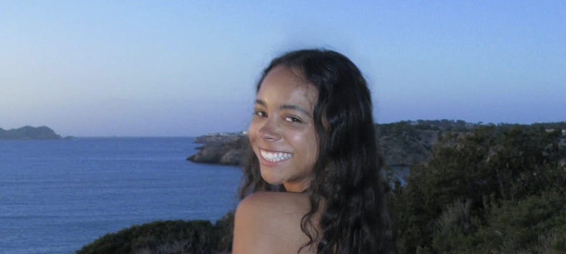 Die britische DJ und Musikproduzentin TSHA im Sommeroutfit am Meer auf Ibiza