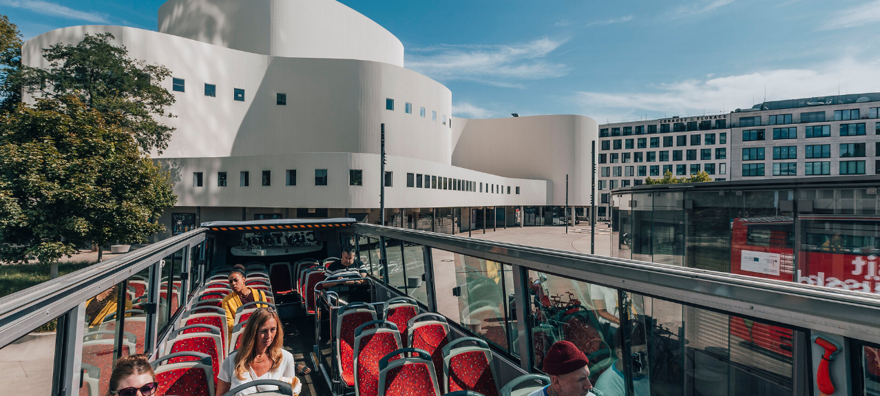 Blick aus dem offenen Hop-on-hop-off-Bus auf das Düsseldorfer Schauspielhaus